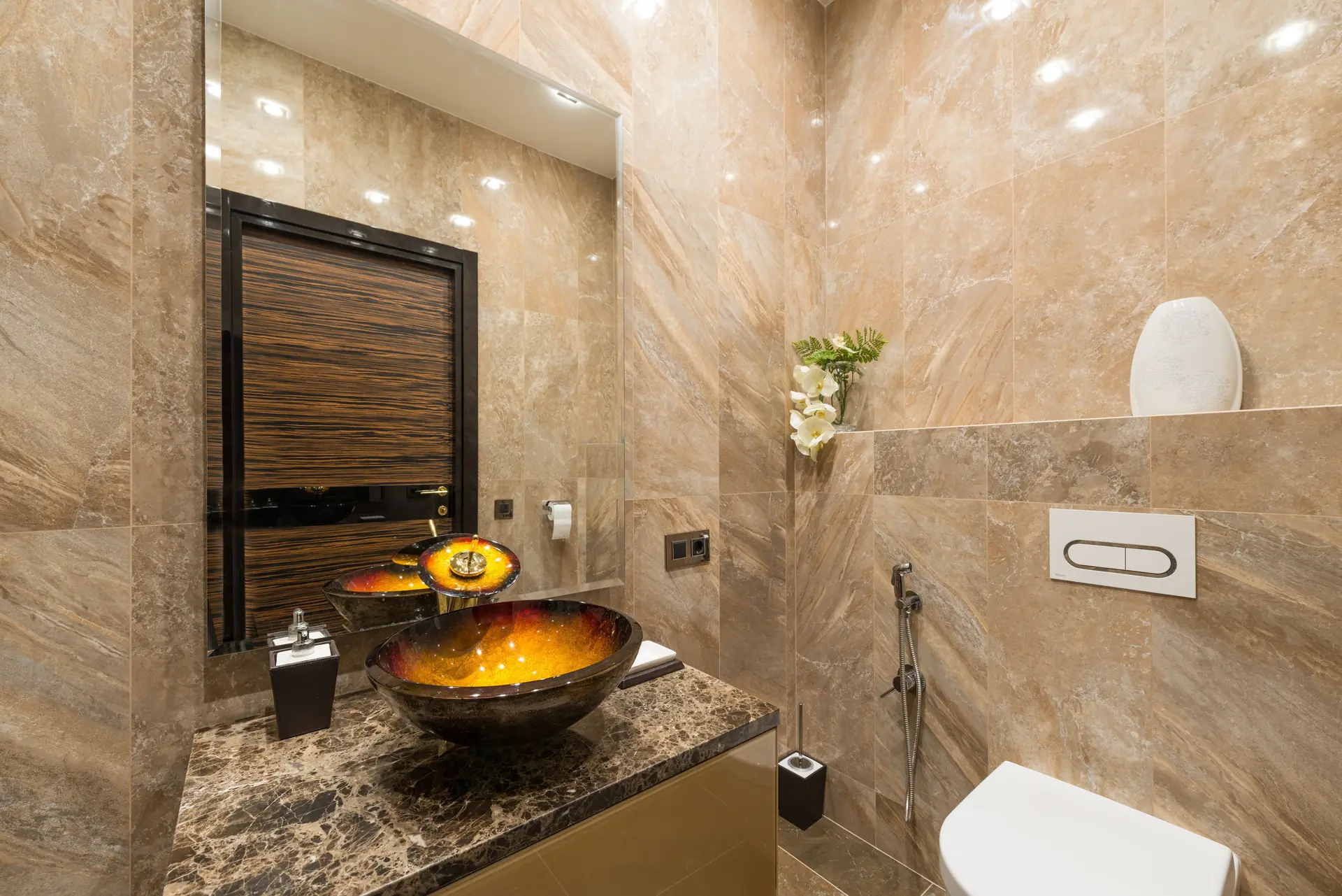 Luxury bathroom with warm golden marble walls and a statement vessel basin